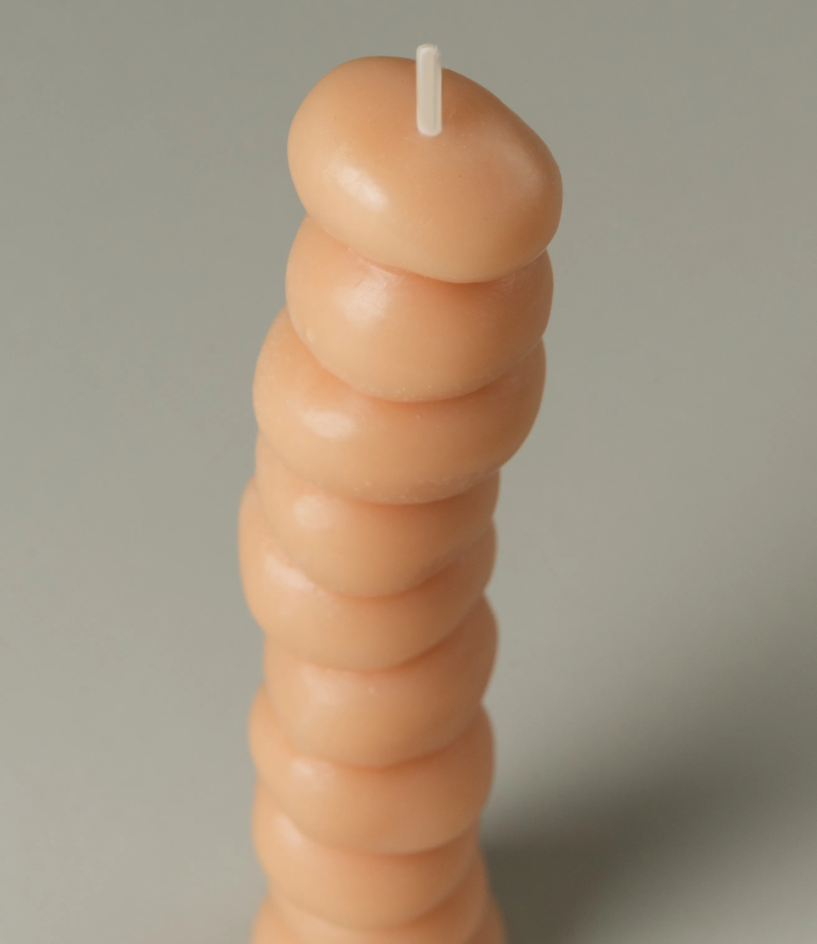 Grape Candle from Ann Vincent has the shape of grapes stacked on top of each other. It has a light nude color.