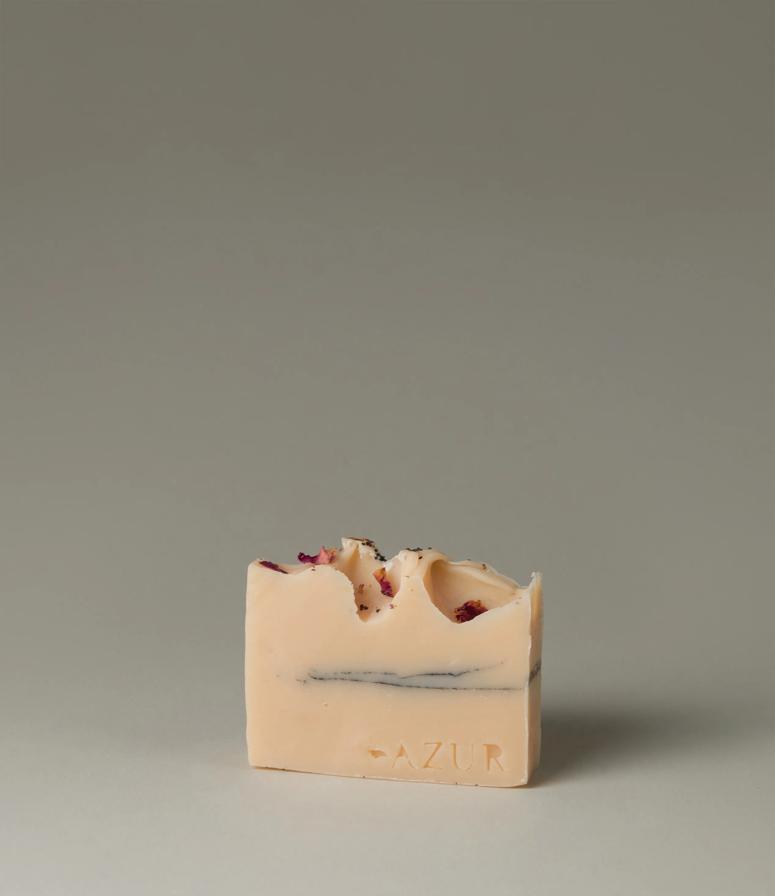 This soap has the scent of Wild Flower and it was crafted by Azur Natural Bodycare. The product merges two colors, light peach and dark grey. The top of the soap looks like the waves of the ocean and is hinted with petals.