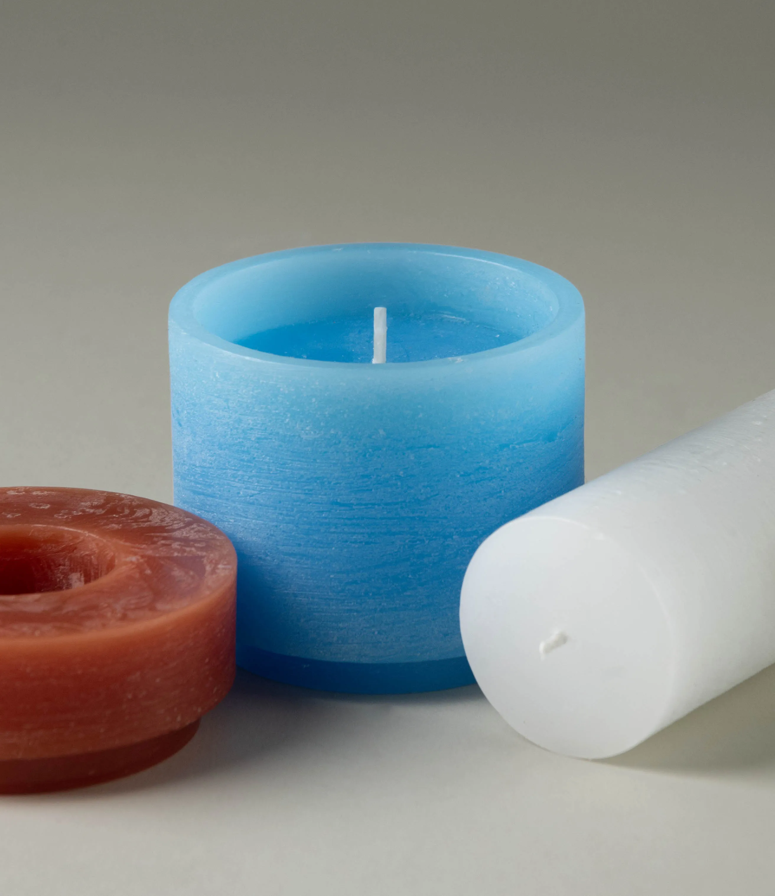 Stackable candle from Stan Editions. This particular piece comes in the color of burgundy, blue and white. The product consists of three pieces, they are unassembled on this picture. The texture of the product is rough gives a brushed effect.