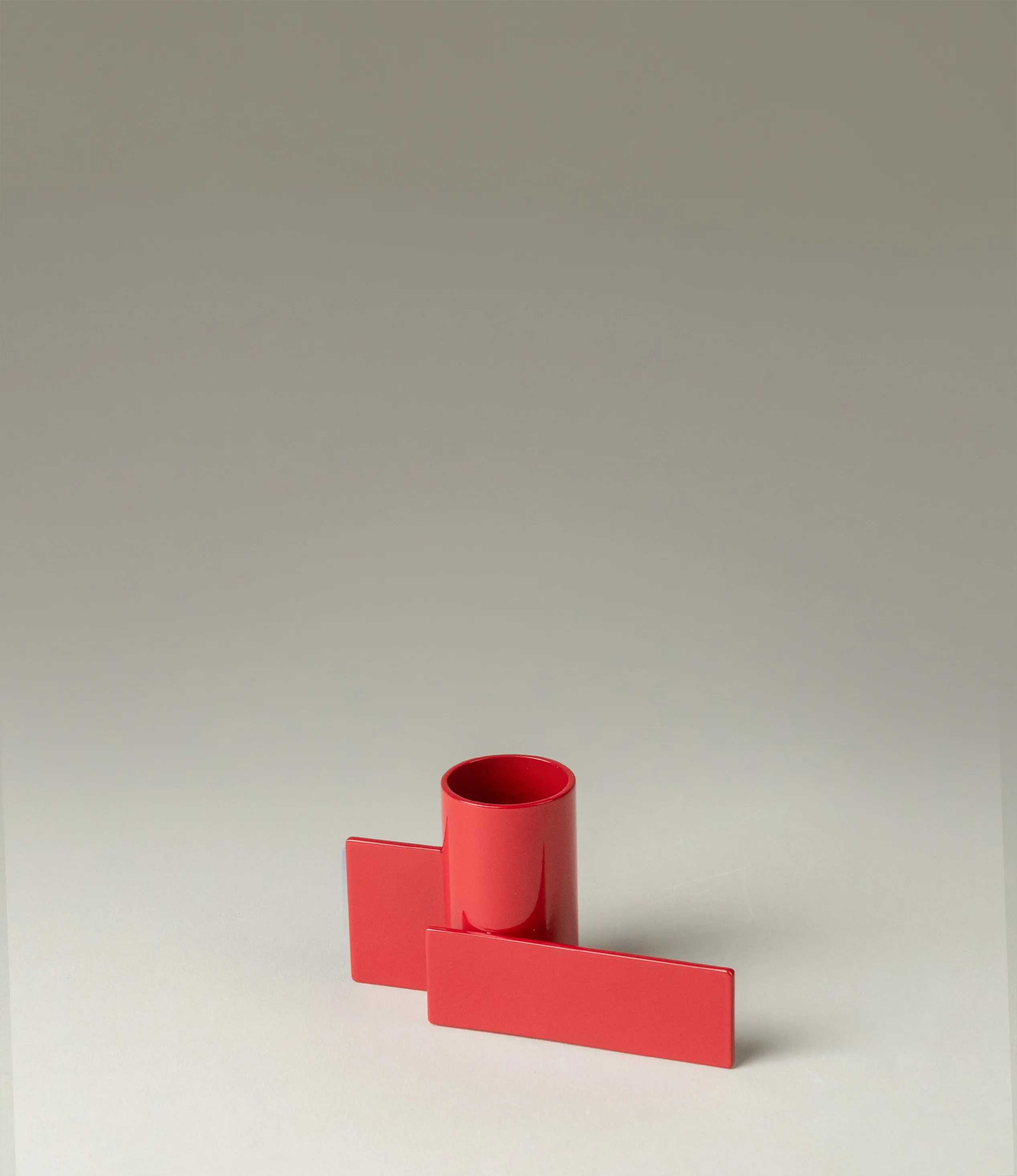 Icon Iysestage 01 from Stences is a candleholder made for taper candles. This picture shows the red variant of this item. The steel material has a glossy surface which emphasize the soft geometric shapes of the product in question.