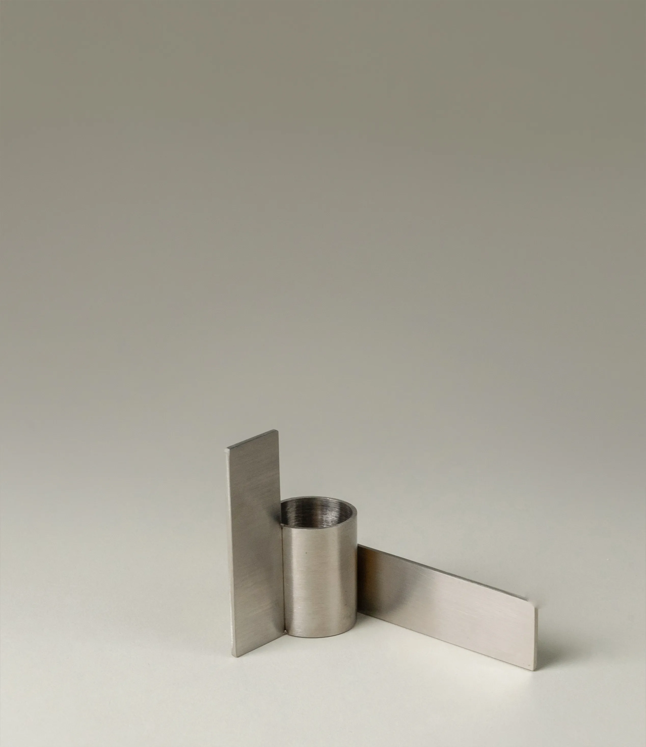 Icon Iysestage 02 from Stences is a candleholder made for taper candles. This picture shows the chrome variant of this item. The steel material has a brushed surface which emphasize the soft geometric shapes of the product in question. Perfect fit for your brutalist, minimalist home.
